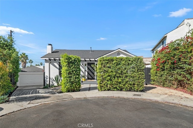2329 Vineyard Ave, Los Angeles, CA 90016 - view of property hidden behind natural elements with an outbuilding, a garage, a chimney, stucco siding, and roof with shingles