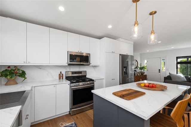2329 Vineyard Ave, Los Angeles, CA 90016 - kitchen with stainless steel appliances, open floor plan, dark wood-type flooring, tasteful backsplash, and hanging light fixtures