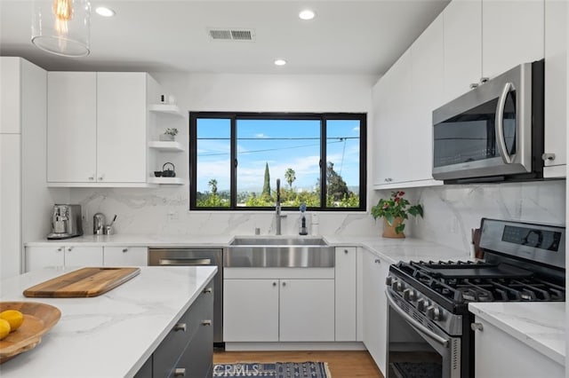 2329 Vineyard Ave, Los Angeles, CA 90016 - kitchen featuring appliances with stainless steel finishes, recessed lighting, white cabinetry, backsplash, and open shelves