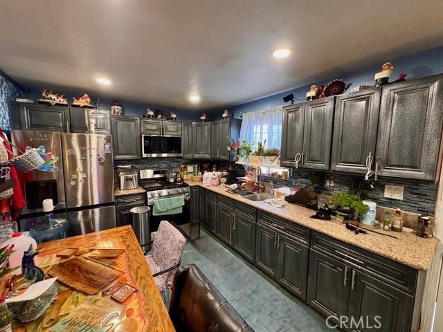 233 W 65th St, Los Angeles, CA 90003 - kitchen with appliances with stainless steel finishes, light countertops, tasteful backsplash, recessed lighting, and dark cabinetry