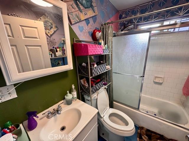 233 W 65th St, Los Angeles, CA 90003 - bathroom featuring vanity, enclosed tub / shower combo, and wallpapered walls