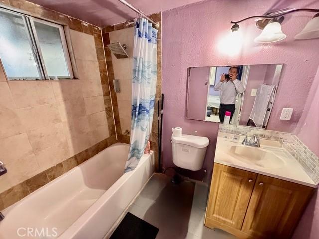 233 W 65th St, Los Angeles, CA 90003 - bathroom featuring shower / tub combo, vanity, and a textured wall