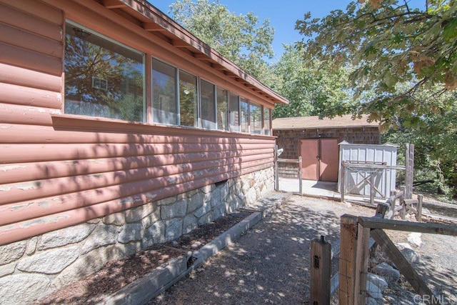 1211 Bridal Path, Rimforest, CA 92378 - view of property exterior with a sunroom, faux log siding, and a shed