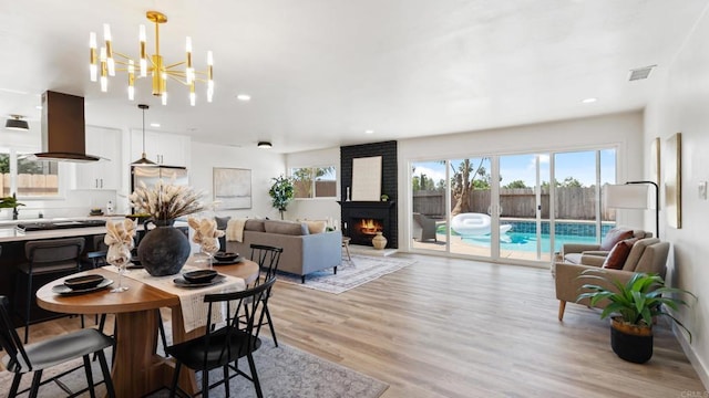 8865 Highsmith Ln, San Diego, CA 92119 - dining room with light wood-style floors, a chandelier, recessed lighting, and a fireplace