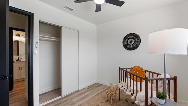 8865 Highsmith Ln, San Diego, CA 92119 - bedroom with light wood-type flooring, a closet, a crib, and a ceiling fan