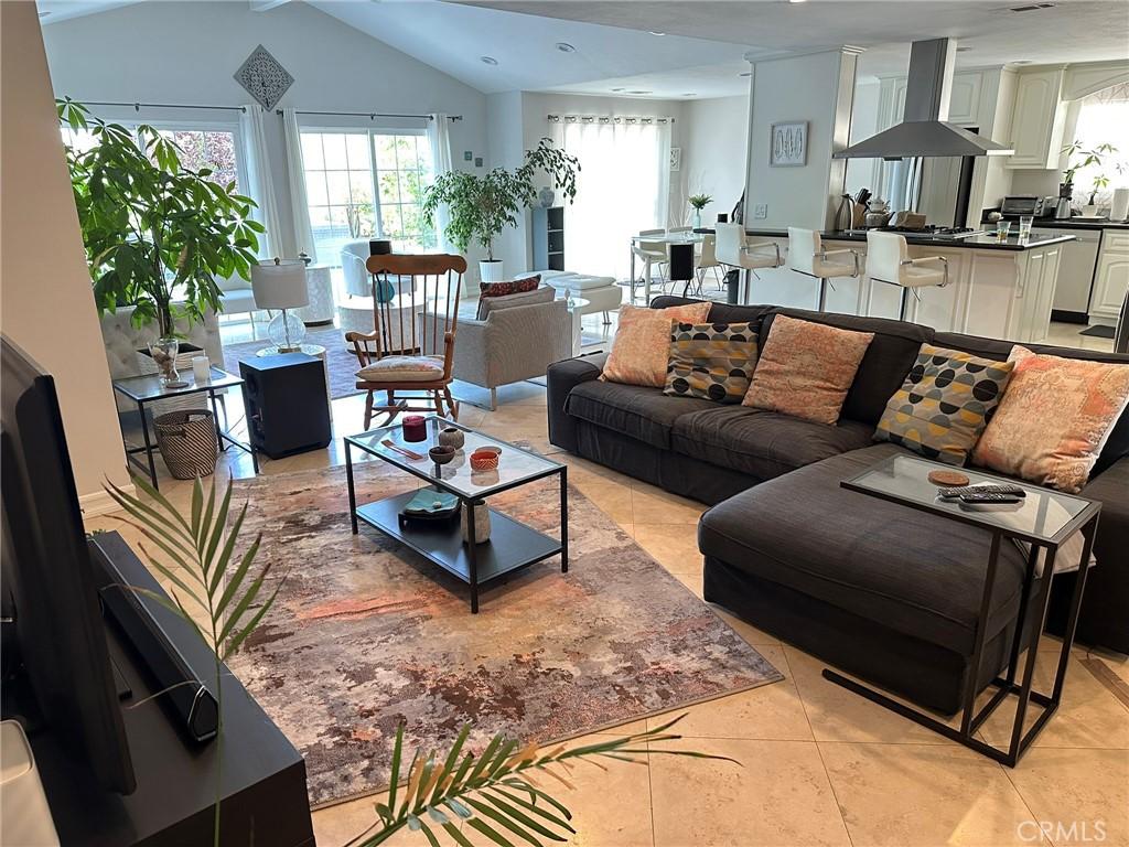 24017 Sylvan St, Woodland Hills, CA 91367 - living room featuring light tile patterned floors, plenty of natural light, and vaulted ceiling