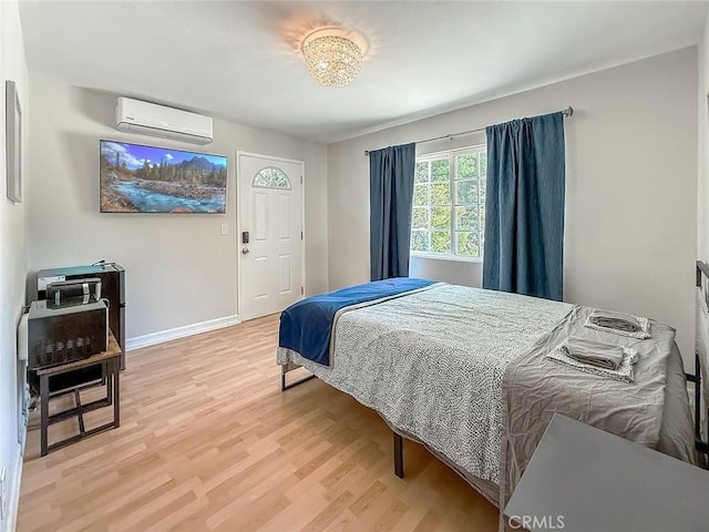 24017 Sylvan St, Woodland Hills, CA 91367 - bedroom with a wall mounted air conditioner and light wood-style flooring