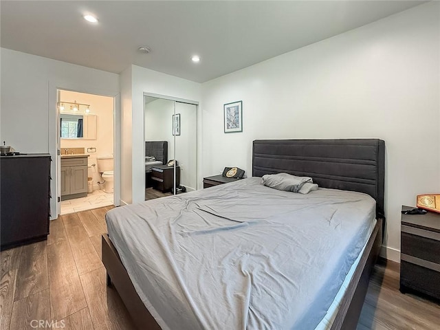 24017 Sylvan St, Woodland Hills, CA 91367 - bedroom featuring wood finished floors, recessed lighting, connected bathroom, a closet, and a chandelier