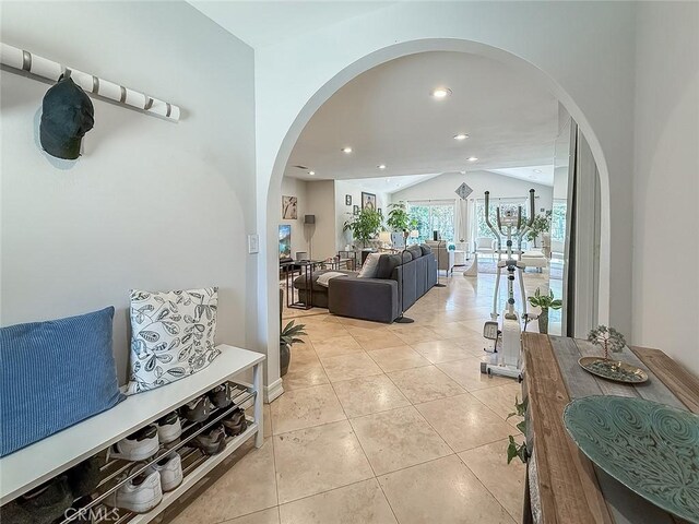 24017 Sylvan St, Woodland Hills, CA 91367 - hallway featuring arched walkways, light tile patterned floors, vaulted ceiling, and recessed lighting