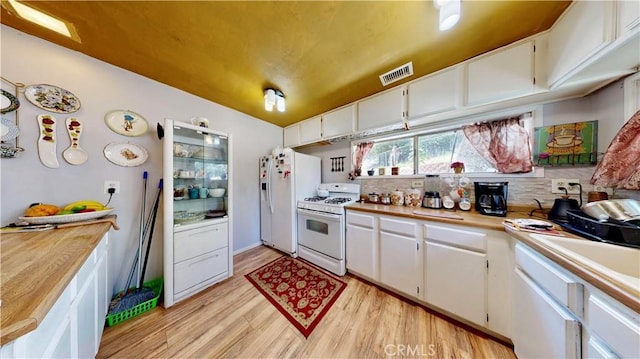 23728 Manzanita Dr, Crestline, CA 92325 - kitchen featuring white appliances, light wood-type flooring, light countertops, decorative backsplash, and white cabinetry