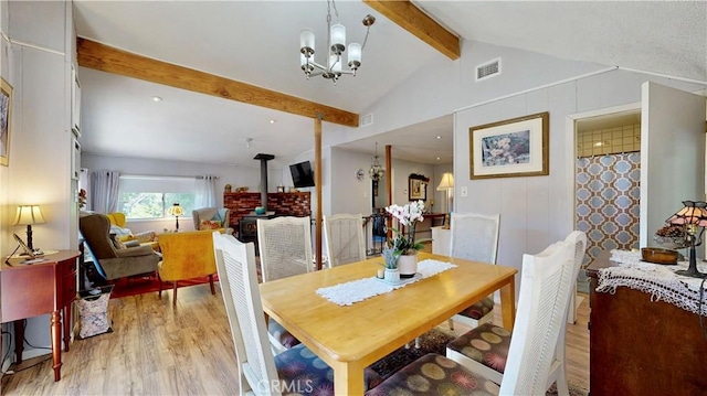 23728 Manzanita Dr, Crestline, CA 92325 - dining area with light wood-style floors, a wood stove, and a chandelier