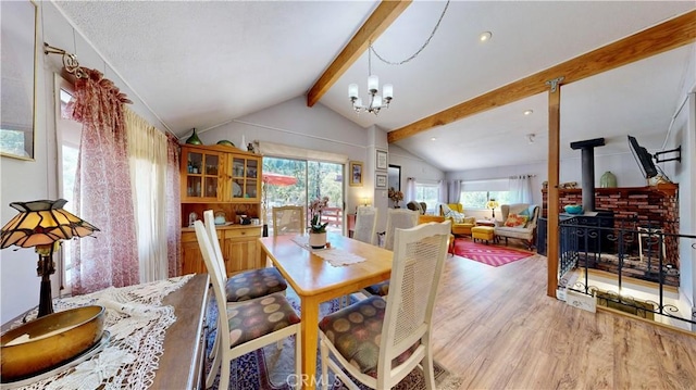 23728 Manzanita Dr, Crestline, CA 92325 - dining room featuring light wood-style flooring, a wood stove, and a chandelier