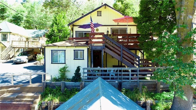 23728 Manzanita Dr, Crestline, CA 92325 - view of front facade with stairway, a wooden deck, and board and batten siding