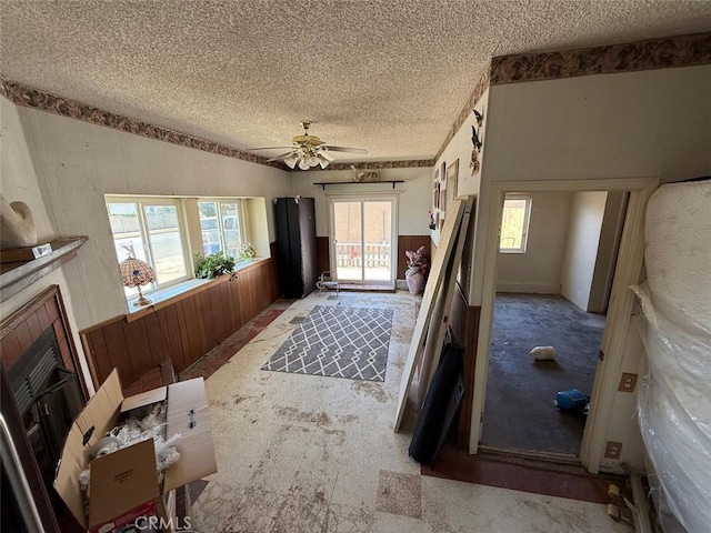 2073 Sandalwood Dr, Santa Maria, CA 93455 - entrance foyer featuring a textured ceiling, ceiling fan, wooden walls, wainscoting, and a fireplace