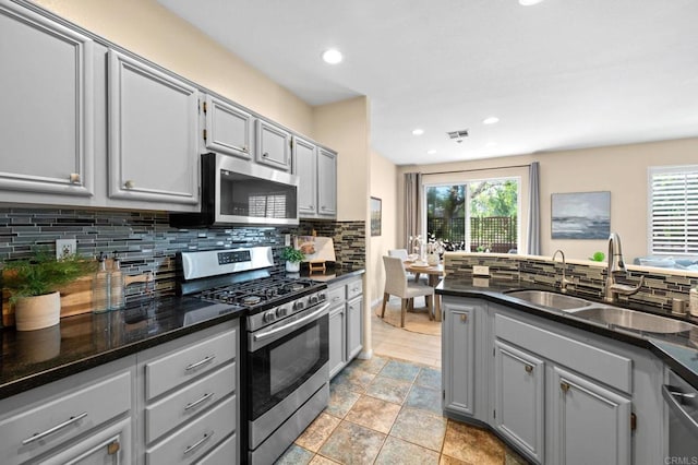 6104 Citracado Cir, Carlsbad, CA 92009 - kitchen featuring appliances with stainless steel finishes, gray cabinetry, tasteful backsplash, recessed lighting, and dark stone countertops