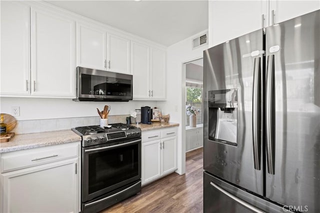 27724 Crookshank Dr, Saugus, CA 91350 - kitchen with stainless steel appliances, white cabinetry, wood finished floors, and light stone counters