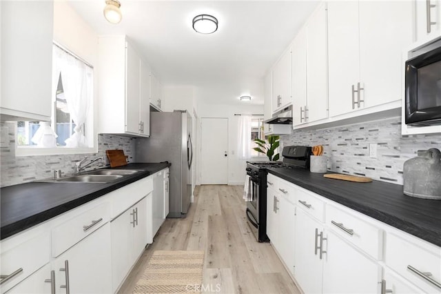 7729 Sedan Ave, West Hills, CA 91304 - kitchen featuring stainless steel range with gas cooktop, black microwave, dark countertops, white cabinetry, and backsplash