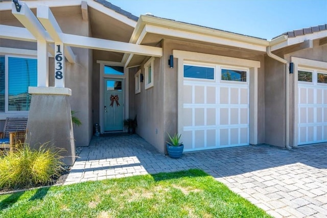 1638 Monterey Ave, Grover Beach, CA 93433 - property entrance featuring stucco siding, decorative driveway, and an attached garage