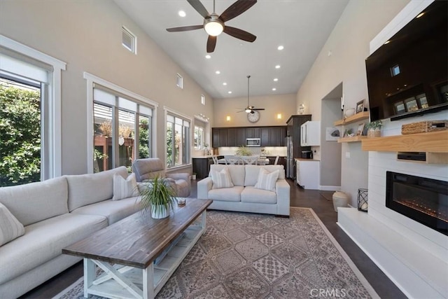 1638 Monterey Ave, Grover Beach, CA 93433 - living area featuring a ceiling fan, a high ceiling, a glass covered fireplace, recessed lighting, and dark wood-style floors