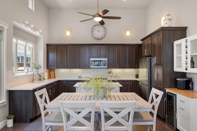 1638 Monterey Ave, Grover Beach, CA 93433 - kitchen featuring stainless steel appliances, high vaulted ceiling, beverage cooler, dark brown cabinetry, and light countertops
