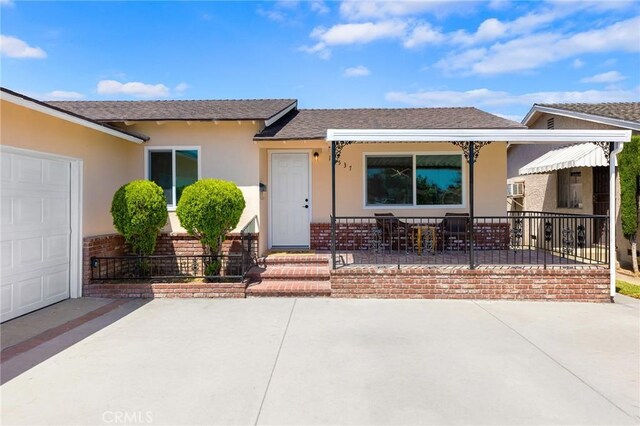 14537 Rath St, La Puente, CA 91744 - view of front facade with stucco siding, covered porch, a shingled roof, and a garage