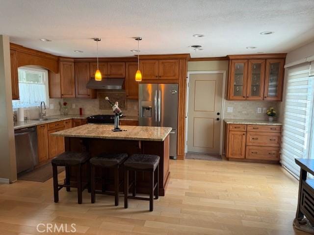 1640 Valencia Ave, Placentia, CA 92870 - kitchen with appliances with stainless steel finishes, under cabinet range hood, brown cabinetry, plenty of natural light, and recessed lighting