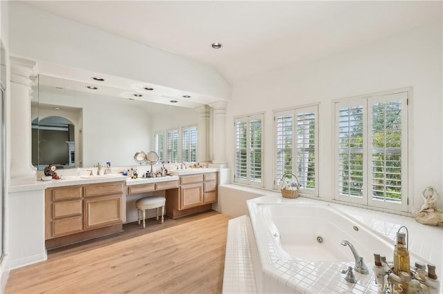 26942 Willow Tree Ln, Laguna Hills, CA 92653 - bathroom with double vanity, a tub with jets, wood finished floors, lofted ceiling, and recessed lighting