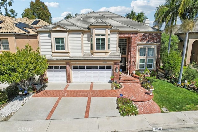 26942 Willow Tree Ln, Laguna Hills, CA 92653 - view of front of home featuring decorative driveway, an attached garage, a tile roof, brick siding, and a front lawn