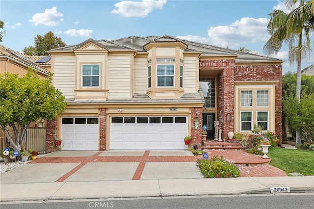 26942 Willow Tree Ln, Laguna Hills, CA 92653 - view of front of house with a garage, concrete driveway, brick siding, and a tile roof