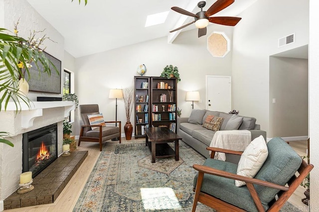 5550 La Cuenta Dr, San Diego, CA 92124 - living room with a ceiling fan, high vaulted ceiling, wood finished floors, a glass covered fireplace, and beam ceiling