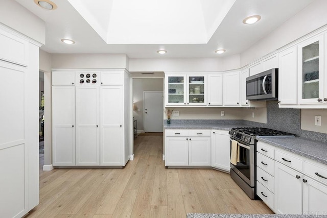 5550 La Cuenta Dr, San Diego, CA 92124 - kitchen with stainless steel appliances, light wood-style flooring, white cabinetry, recessed lighting, and glass insert cabinets