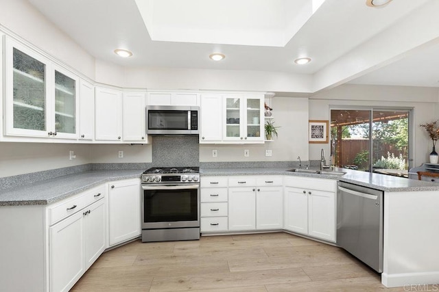 5550 La Cuenta Dr, San Diego, CA 92124 - kitchen featuring appliances with stainless steel finishes, a peninsula, white cabinets, recessed lighting, and light wood-type flooring