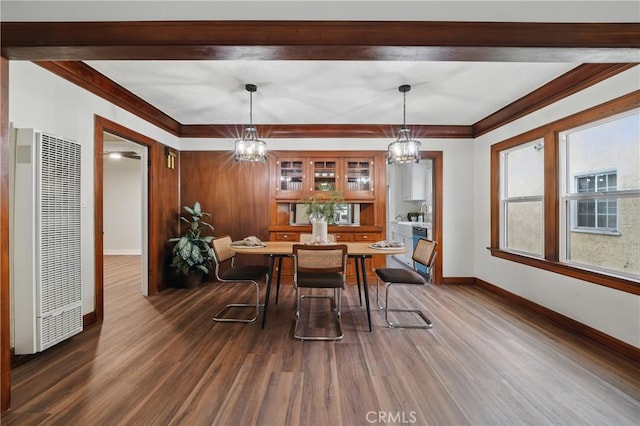 8680 Evergreen Ave, South Gate, CA 90280 - dining room featuring a heating unit, dark wood-style floors, a chandelier, and ornamental molding