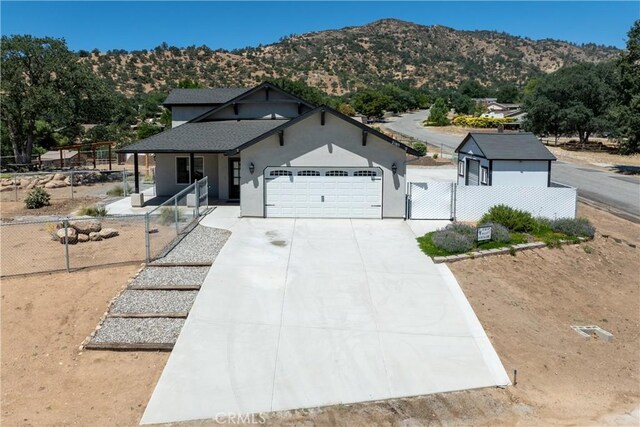 21813 Valley Vista Dr, Tehachapi, CA 93561 - view of front of property featuring an attached garage, a mountain view, driveway, covered porch, and a gate