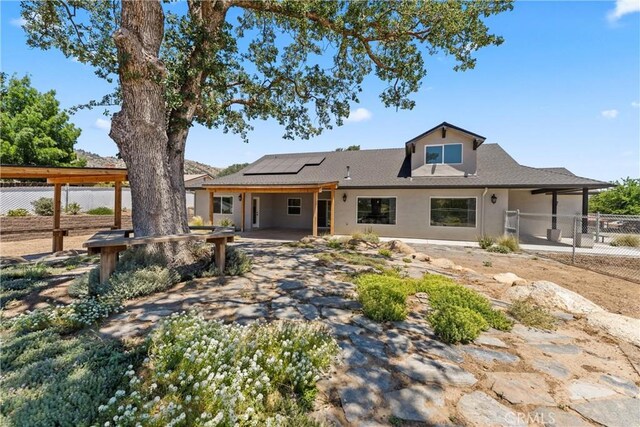 21813 Valley Vista Dr, Tehachapi, CA 93561 - rear view of house with roof mounted solar panels, a patio, and stucco siding