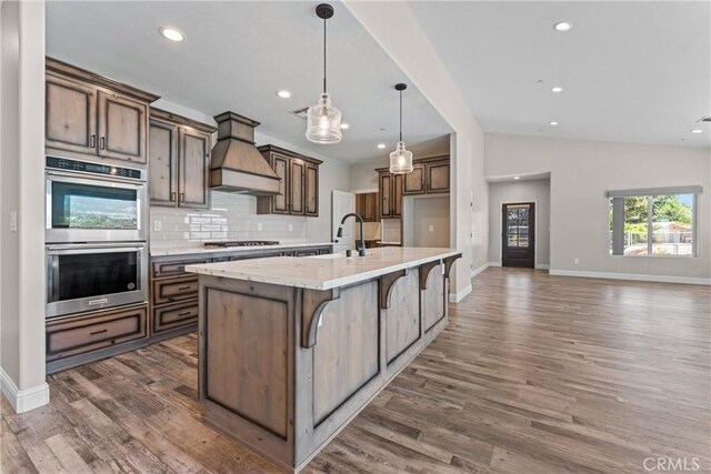 21813 Valley Vista Dr, Tehachapi, CA 93561 - kitchen featuring stainless steel appliances, custom range hood, vaulted ceiling, backsplash, and dark wood finished floors