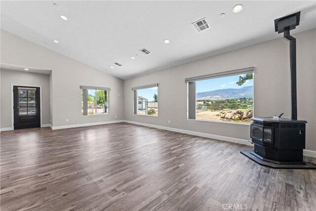 21813 Valley Vista Dr, Tehachapi, CA 93561 - unfurnished living room featuring a wood stove, lofted ceiling, recessed lighting, and wood finished floors