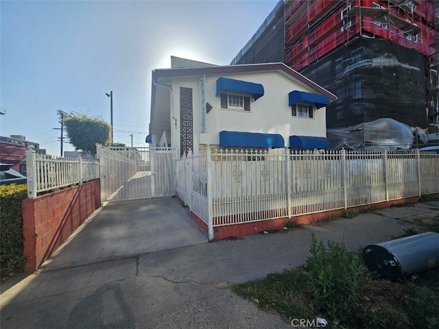 981 S Catalina St, Los Angeles, CA 90006 - view of home's exterior with a fenced front yard, stucco siding, and a gate