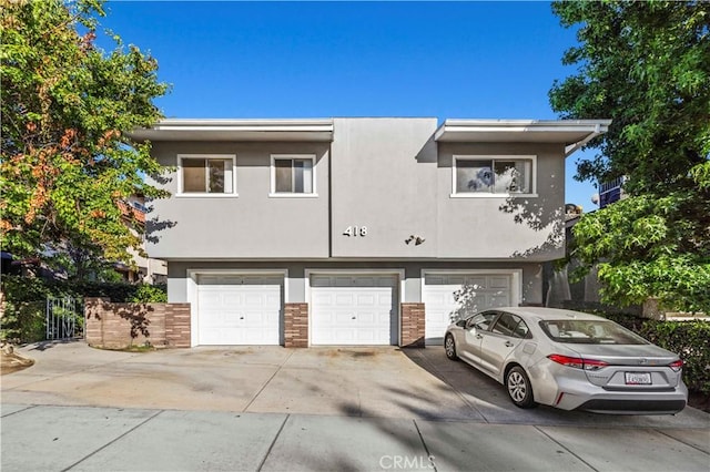 418 E Harvard Rd Unit D, Burbank, CA 91501 - view of property with a garage, driveway, and stucco siding