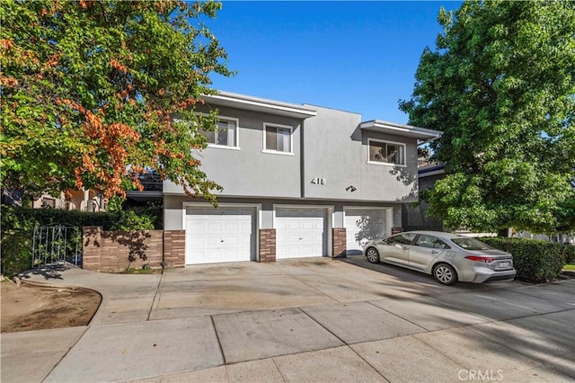 418 E Harvard Rd Unit D, Burbank, CA 91501 - view of property with a garage, driveway, and stucco siding