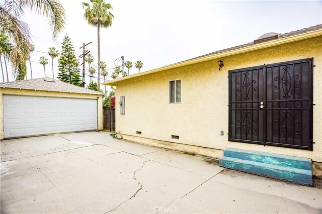 4519 9th Ave, Los Angeles, CA 90043 - view of side of home featuring crawl space, mail area, an outbuilding, a detached garage, and stucco siding