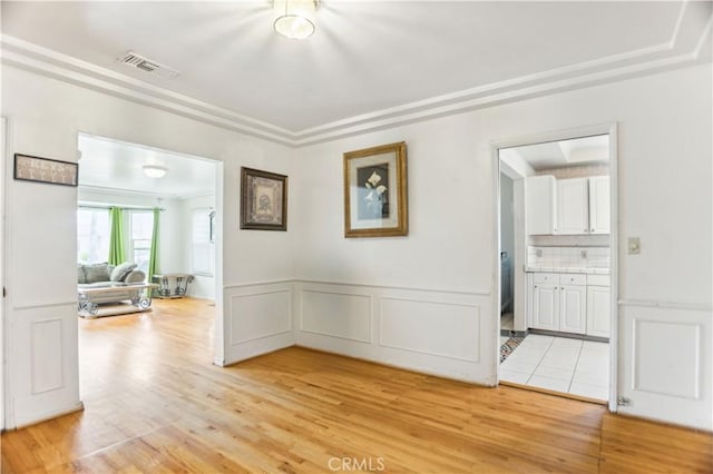 4519 9th Ave, Los Angeles, CA 90043 - unfurnished room with light wood finished floors, a decorative wall, and wainscoting
