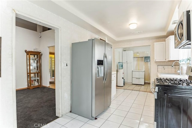 4519 9th Ave, Los Angeles, CA 90043 - kitchen featuring stainless steel appliances, light tile patterned flooring, white cabinets, and light countertops