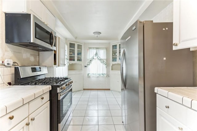 4519 9th Ave, Los Angeles, CA 90043 - kitchen with stainless steel appliances, tile countertops, backsplash, and white cabinetry