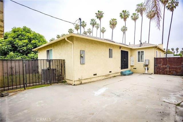 4519 9th Ave, Los Angeles, CA 90043 - rear view of property featuring stucco siding, a patio, a gate, and crawl space