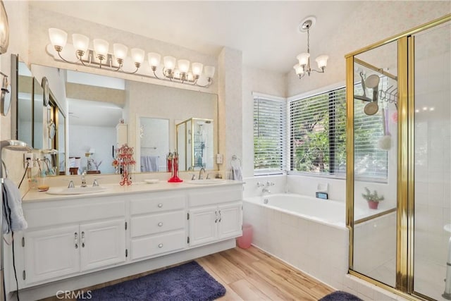 22024 Jeffers Ln, Saugus, CA 91350 - bathroom featuring wood finished floors, double vanity, a garden tub, a stall shower, and a chandelier