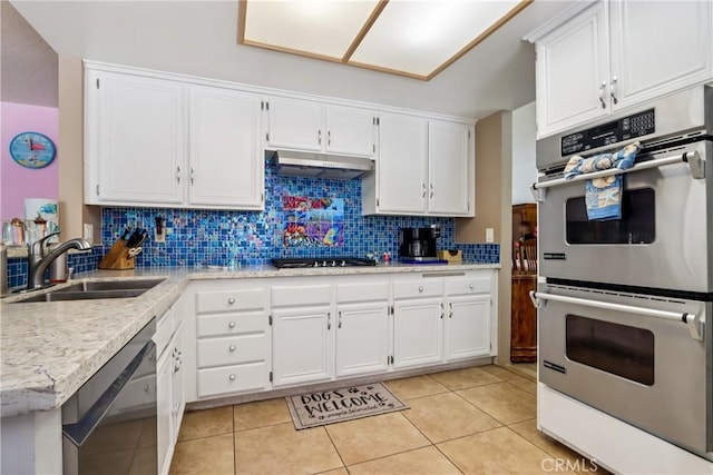 22024 Jeffers Ln, Saugus, CA 91350 - kitchen featuring stainless steel appliances, under cabinet range hood, decorative backsplash, white cabinets, and light tile patterned floors