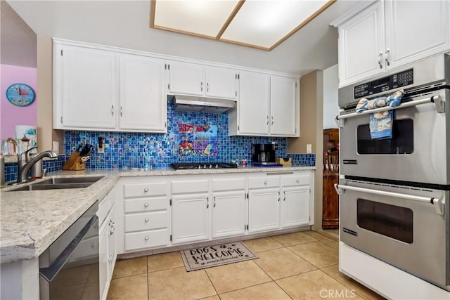 22024 Jeffers Ln, Saugus, CA 91350 - kitchen featuring stainless steel appliances, under cabinet range hood, decorative backsplash, white cabinetry, and light tile patterned floors