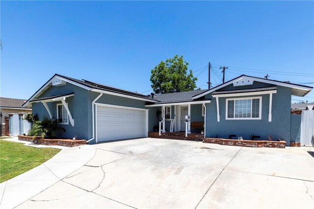 14913 San Ardo Dr, La Mirada, CA 90638 - ranch-style house with stucco siding, concrete driveway, an attached garage, and covered porch