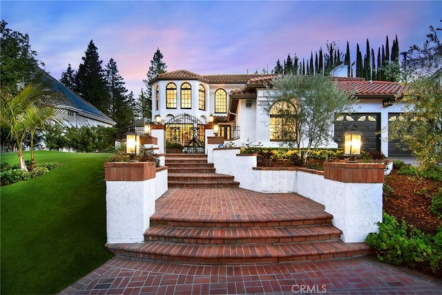 29614 Ridgeway Dr, Agoura Hills, CA 91301 - mediterranean / spanish-style house featuring a tiled roof, a lawn, an attached garage, and stucco siding